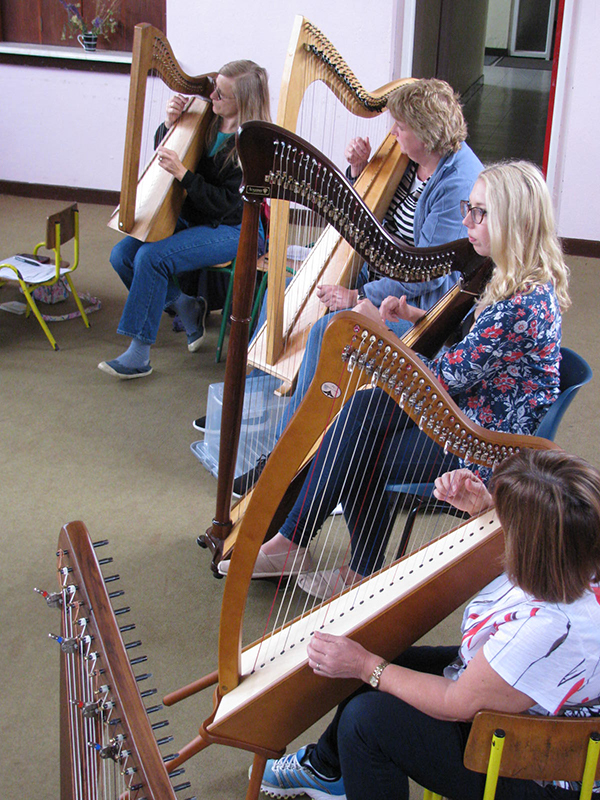 Participants practicising the Irish harp at Oideas Gael.