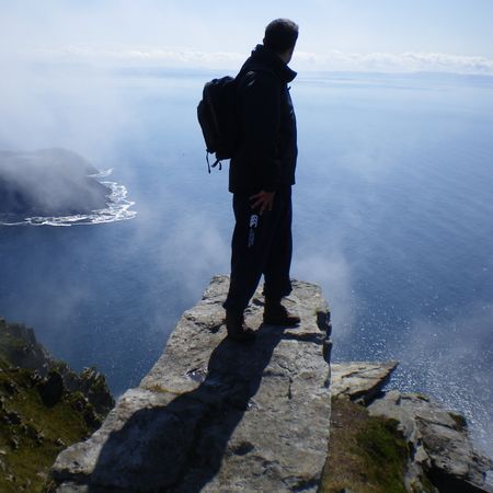 A hill walker looking out to sea from the top of Sliabh Liag