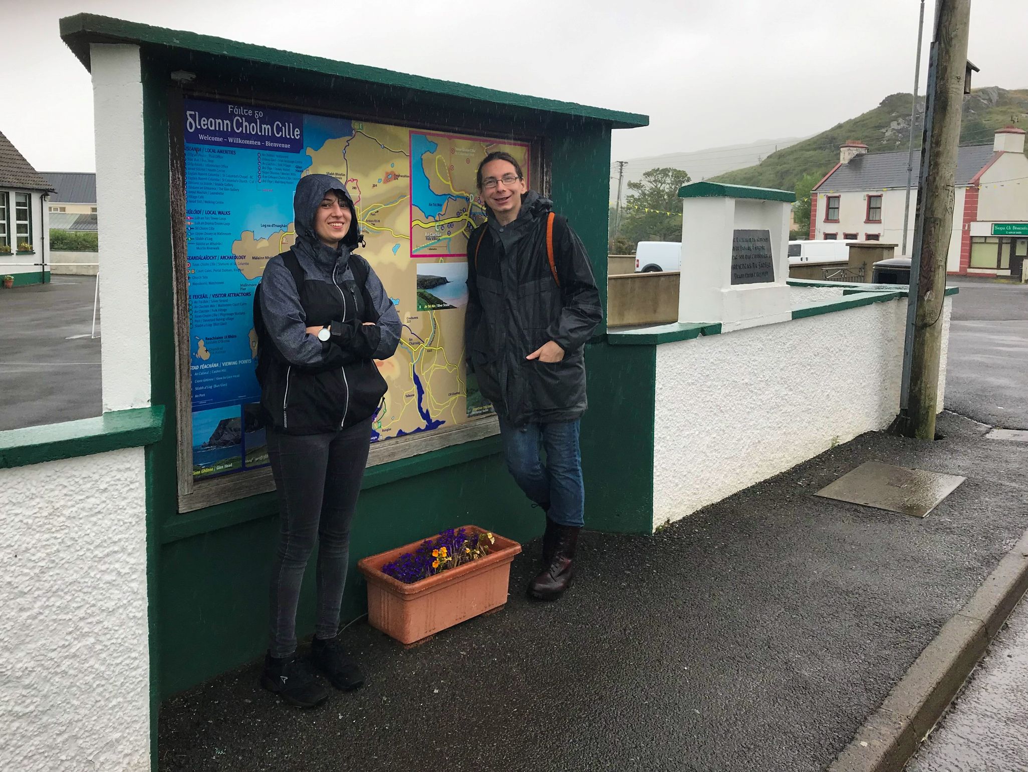 Beirt ag an stad bus ar lá fliuch
