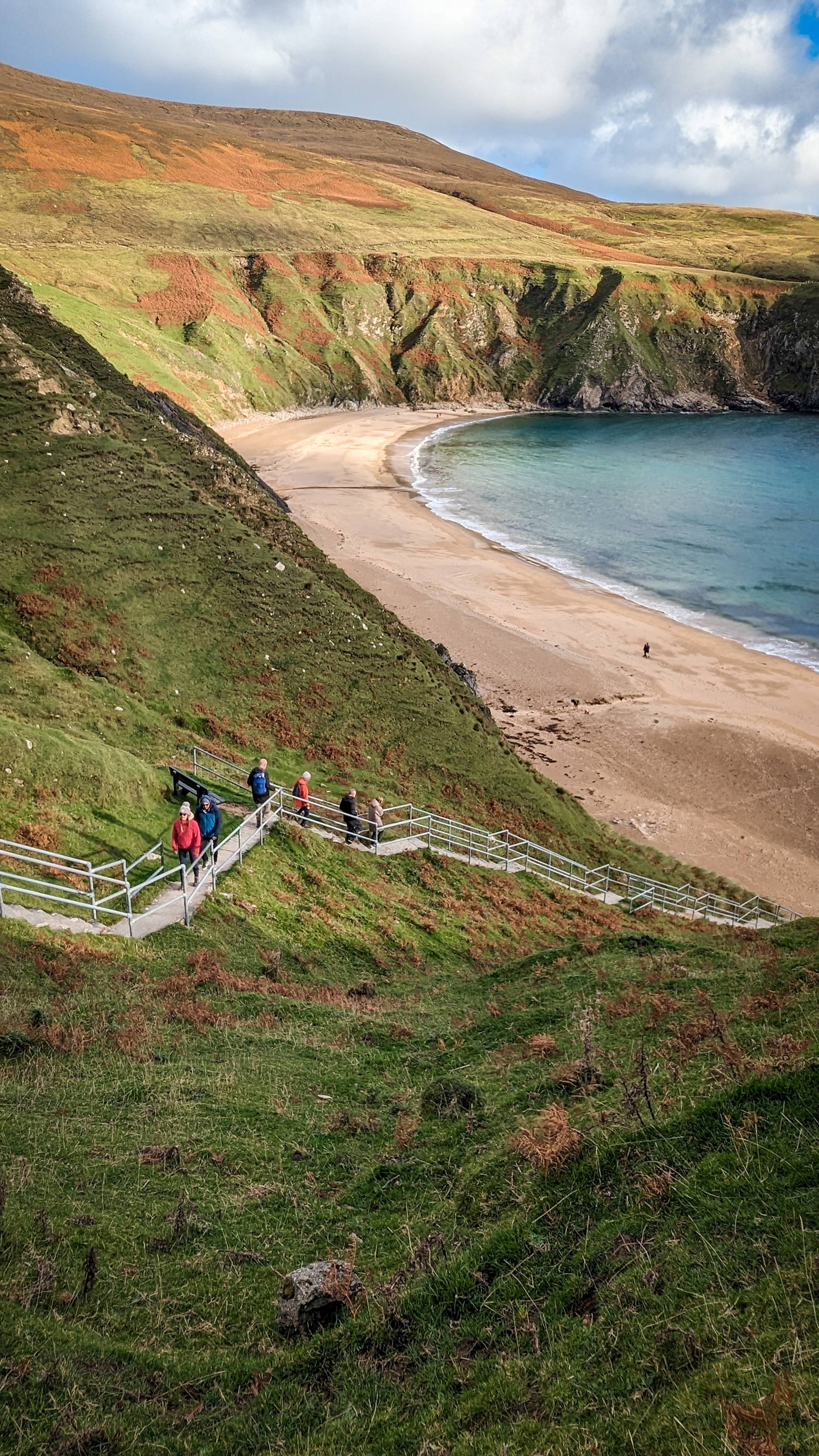 Ag dul síos na céimeanna chuig an Trá Bhán, ar an Mhálainn Bhig